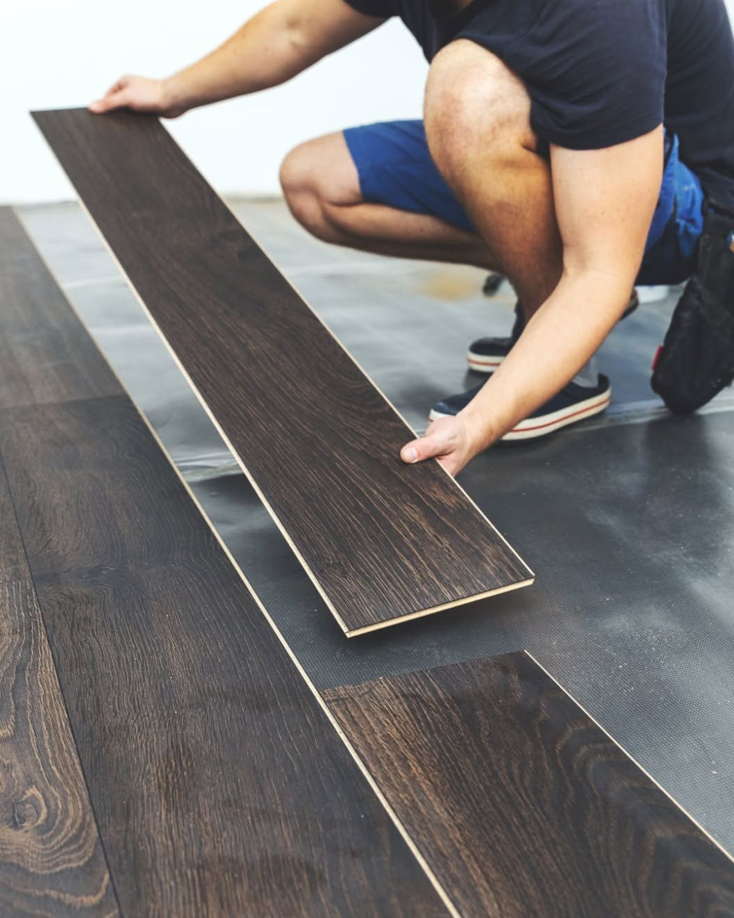 Dark wood-look plank flooring being installed