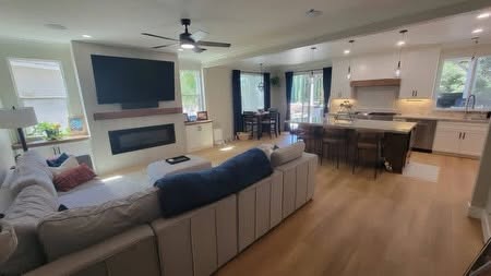 Open living room and kitchen with light wood-look flooring — Sulca's Carpets Instagram